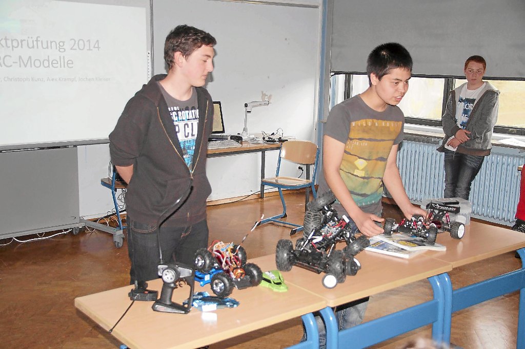 Alex Krampf (Mitte) präsentiert  eines seiner Modelle, die  die Anregung für das Thema  Funkferngesteuerte Fahrzeuge für die Projektprüfung gaben. Im Bild außerdem Christoph Kunz (links) und Jochen Kleiser (rechts).  Foto: Heimpel Foto: Schwarzwälder-Bote