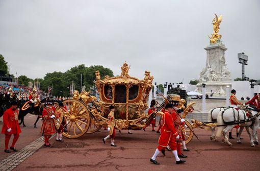 Die goldene Staatskutsche beim Umzug vor dem Buckingham-Palast. Im hinteren Fenster einen Hologramm der jungen Queen. Foto: dpa/Hannah Mckay