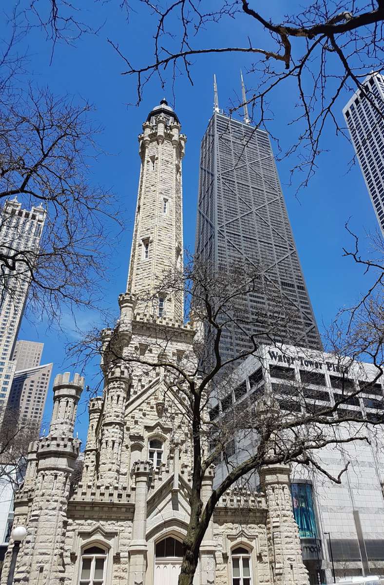 Der alte Wasserturm aus dem Jahr 1869 an der North Michigan Avenue (rechts daneben das John Hancock Center) gehört zu den wenigen Gebäuden, die den Großen Brand von Chicago im Jahr 1871 überstanden haben.