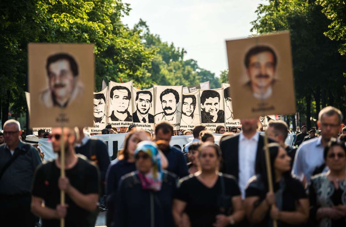 Demonstranten halten  in München 2018 bei einer Kundgebung Schilder mit Abbildungen der NSU-Opfer hoch. Foto: dpa/Lino Mirgeler