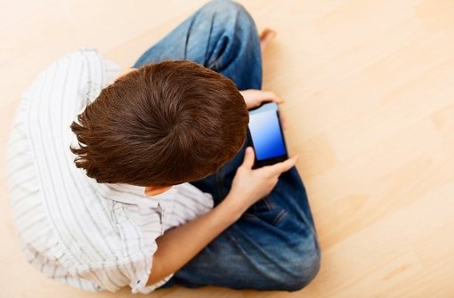 Das Handy gehört zum Alltag: Ein Junge spielt auf seinem Smartphone. Foto: Fotolia