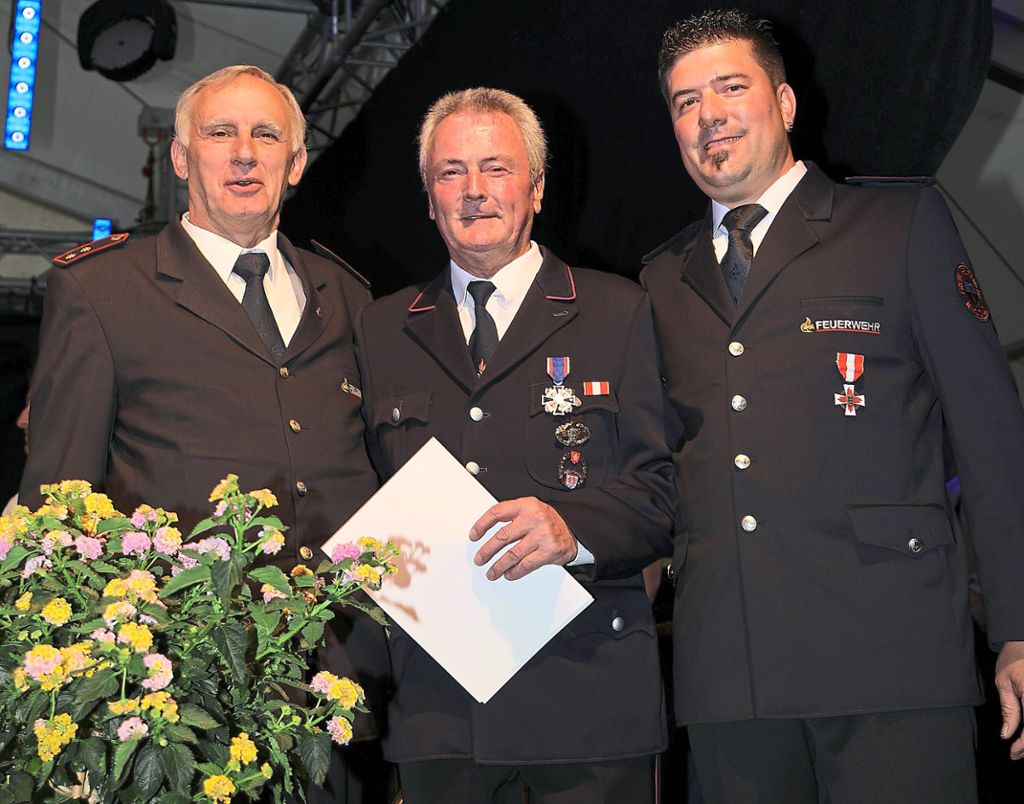 Klaus Ziegler (links) und Timo Müssigmann (rechts) ehrten Helmut Falb mit dem Ehrenkreuz des Deutschen Feuerwehrverbandes.