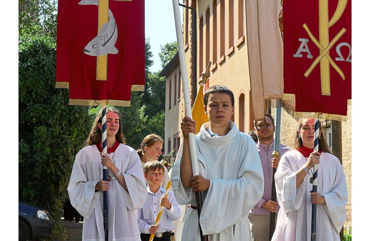 Ministranten tragen bei der Prozession in Schuttern die Fahnen der Kirche. Foto: Bohnert-Seidel