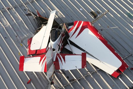 Völlig demoliert liegt das Flugzeugwack des 74-Jährigen auf dem Dach der Lagerhalle, die durch die Wucht des Aufpralls durchschlagen wurde. Foto: Eich