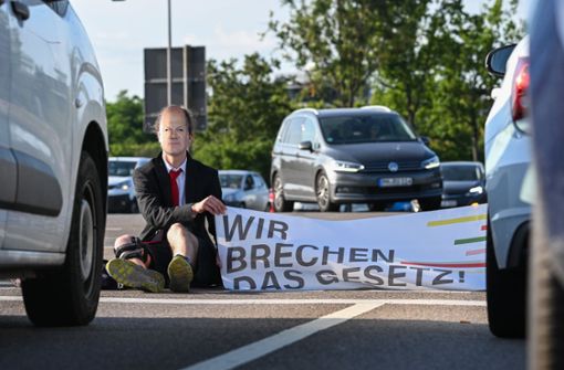 Ein Mitglied der Klimaschutzbewegung „Letzte Generation“ nimmt in Dresden am Freitagmorgen an einer Sitzblockade an der Autobahnabfahrt am Elbepark teil. Foto: dpa/Robert Michael