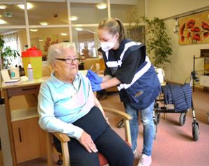 Gertrud Ruf, 97, ist Heimbeirätin im Haus der Pflege St. Verena in Straßberg – und als erste Seniorin im Zollernalbkreis gegen das neuartige Coronavirus geimpft worden. Medizinstudentin Anna Gärtner setzt ihr die Spritze mit viel Feingefühl.  Foto: Eyrich