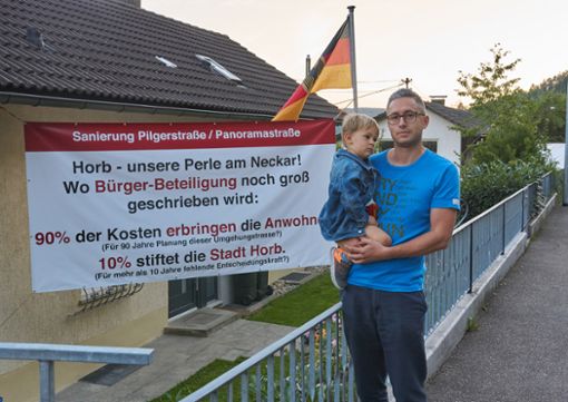 Daniel Leib und sein Sohn Adrian vor einem der großen Transparents in der Panoramastraße. Foto: Lück
