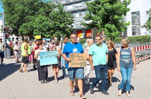 Rund 100 Spaziergänger protestieren in der Schwenninger Innenstadt gegen die Schließung des Friedensschulbades. Foto: Heinig