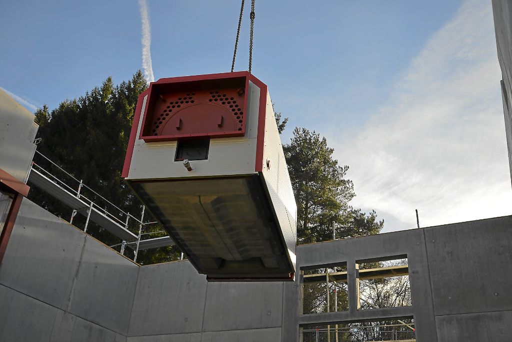 Durch das noch offene Dach des Rohbaus wurde  die tonnenschwere technische Ausrüstung in die Heizzentrale für die Nahwärmeversorgung in Niedereschach gehievt.   Foto: Bantle Foto: Schwarzwälder-Bote