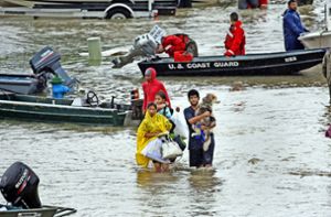 Menschen waten in Houston (US-Bundesstaat Texas) über die überflutete Tidwell Road. Der Tropensturm Harvey hat schwere Verwüstungen angerichtet und Überschwemmungen verursacht Foto: AP