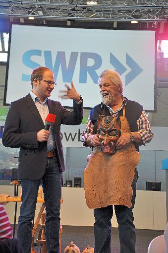 Bruno Springmann führte den SWR-Radiomoderator Markus Bender auf der Showbühne in Halle 6 in die hohe Kunst des Maskenschnitzens ein. Der Horber Beitrag zur CMT wurde live im Radio übertragen. Foto: Raible Foto: Raible