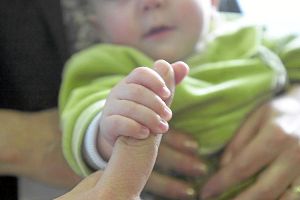 Ein Baby hält den Finger eines Erwachsenen. Wenn Kinder vernachlässigt werden, kann sie auch im Zollernalbkreis das Jugendamt in Obhut geben – für eine Weile oder auf Dauer. Foto: SB-Archiv