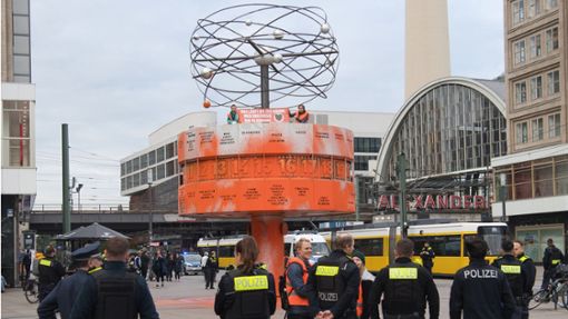 Aktivisten der Gruppe Letzte Generation haben die Weltzeituhr am Alexanderplatz Orange eingefärbt. Die Polizei kommt zu spät, obwohl sich ein Revierposten nur wenige Meter entfernt befindet. Foto: dpa/Paul Zinken