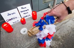 In Stuttgart haben sich die Mitarbeiter des französischen Generalkonsulats an einer Schweigeminute für die Opfer des Attentats auf Charlie Hebdo beteiligt. Vor dem Eingang wurden am Donnerstag Blumen niedergelegt. Foto: dpa