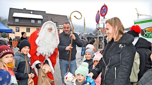 Viele leckere Weckenmänner werden vom Nikolaus in Begleitung von Bürgermeister Markus Keller auf dem Blumberger Weihnachtsmarkt an die kleinen und großen Besucher verteilt. Foto: Hans Herrmann