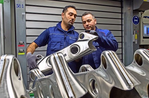Ein syrischer Praktikant lässt sich in der Daimler-Gießerei in Esslingen-Mettingen von seinem Paten einen Achsträger zeigen Foto: dpa