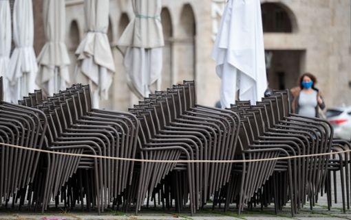 Aufeinander gestapelte Stühle eines geschlossenen Gastronomiebetriebs stehen auf dem Stuttgarter Schloßplatz. Foto: Marijan Murat/dpa
