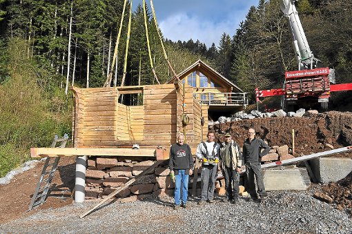 In einem Stück wurde die Blockhütte von Michael Reimold (rechts) und seinen fleißigen Helfern  an ihren neuen Standort gehievt. Foto: GFT Foto: Schwarzwälder-Bote