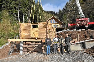 In einem Stück wurde die Blockhütte von Michael Reimold (rechts) und seinen fleißigen Helfern  an ihren neuen Standort gehievt. Foto: GFT Foto: Schwarzwälder-Bote