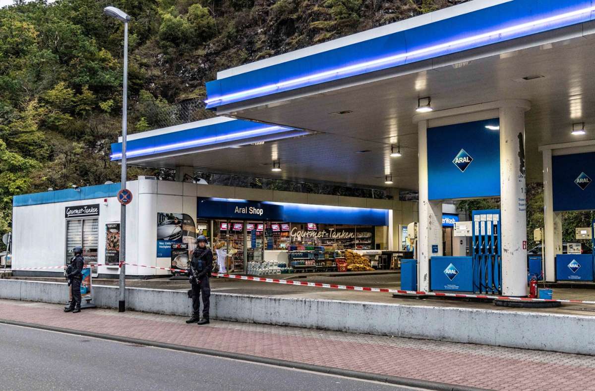 Polizisten sichern am frühen Morgen eine Tankstelle, in der am Vortag ein  49-Jähriger einem 20 Jahre alten Kassierer in den Kopf geschossen hatte. Foto: dpa/Christian Schulz