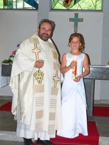 Kommunionkind Marie Schirk zusammen mit Pfarrer Joachim Sohn.    Foto: Heimpel Foto: Schwarzwälder Bote