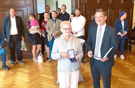 Monika von Pigage wurde im Auftrag des Bundespräsidenten von Klaus Mack mit dem Verdienstorden der Bundesrepublik ausgezeichnet, im Hintergrund ihre Familie. Foto: Bechtle