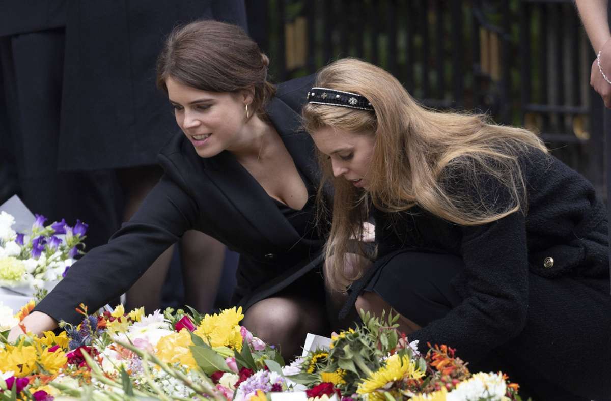 Die Prinzessinnen Eugenie (links) und Beatrice sehen sich in Balmoral die Blumen und Briefe an, die Trauernde vor den Toren des schottischen Landsitzes der Queen hinterlassen haben. Foto: IMAGO/i Images/IMAGO/Stephen Lock / i-Images