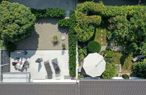 Zwei Gärten in einer Reihenhaussiedlung: Links ein Schottergarten, rechts ein begrünter Garten. (Symbolfoto) Foto: dpa/Felix Kästle