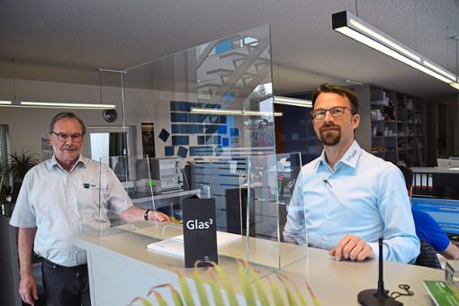 Die Geschäftsführer Fritz Holpp (links) und Christian Holpp zeigen eine  aus Echtglas gefertigte Tröpfchenbarriere zum Schutz gegen Corona-Ansteckungen. Foto: Visel