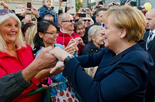 Auch dafür war am Tag der Deutschen Einheit Zeit: Angela Merkel schüttelt in Stuttgart einige Hände. Klicken Sie sich durch die Bilder vom Besuch der Kanzlerin und des Bundespräsidenten Joachim Gauck in Stuttgart! Foto: dpa