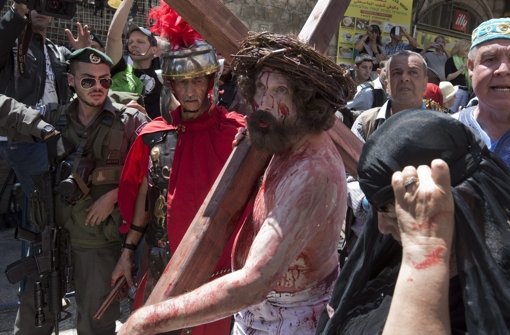 Sie schleppen große Holzkreuze und laufen den Leidensweg Jesu ab: Weltweit erleben Christen den Karfreitag hautnah mit. Foto: dpa