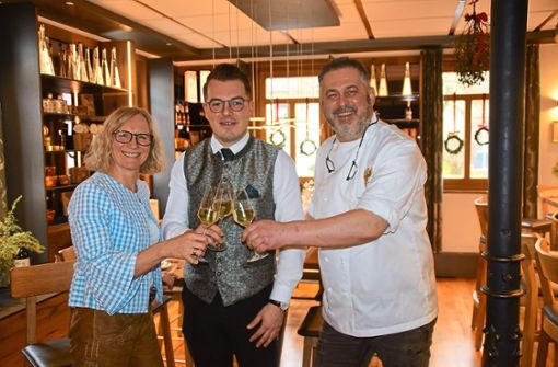 Mit einem Glas Champagner stoßen Martina und Klaus Sauter mit Marc Kotscherowski auf dessen landesweit besten Abschluss als Restaurantfachmann an. Foto: Visel