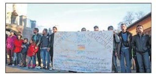 Mit einem großen Plakat versammelten sich die Flüchtlinge vor der Stadtkirche, um auf die Missstände in der Unterkunft in der Friedhofsstraße aufmerksam zu machen.  Foto: Teufel