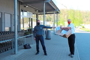 Bürgermeister Gerd Hieber überreicht Edeka-Inhaber Gerald Fauser einen Karton mit Masken. Foto: Steinmetz