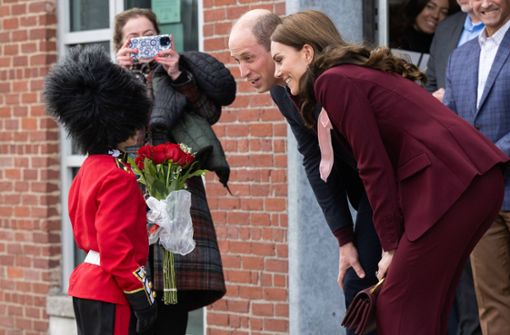 Als  königliche Garde gekleidet, wartet der acht-jährige Henry vor den Greentown Labs in Bostons Nachbarstadt Somerville und überreicht den Royals einen Blumenstrauß. Foto: IMAGO/i Images/IMAGO/i-Images / Pool