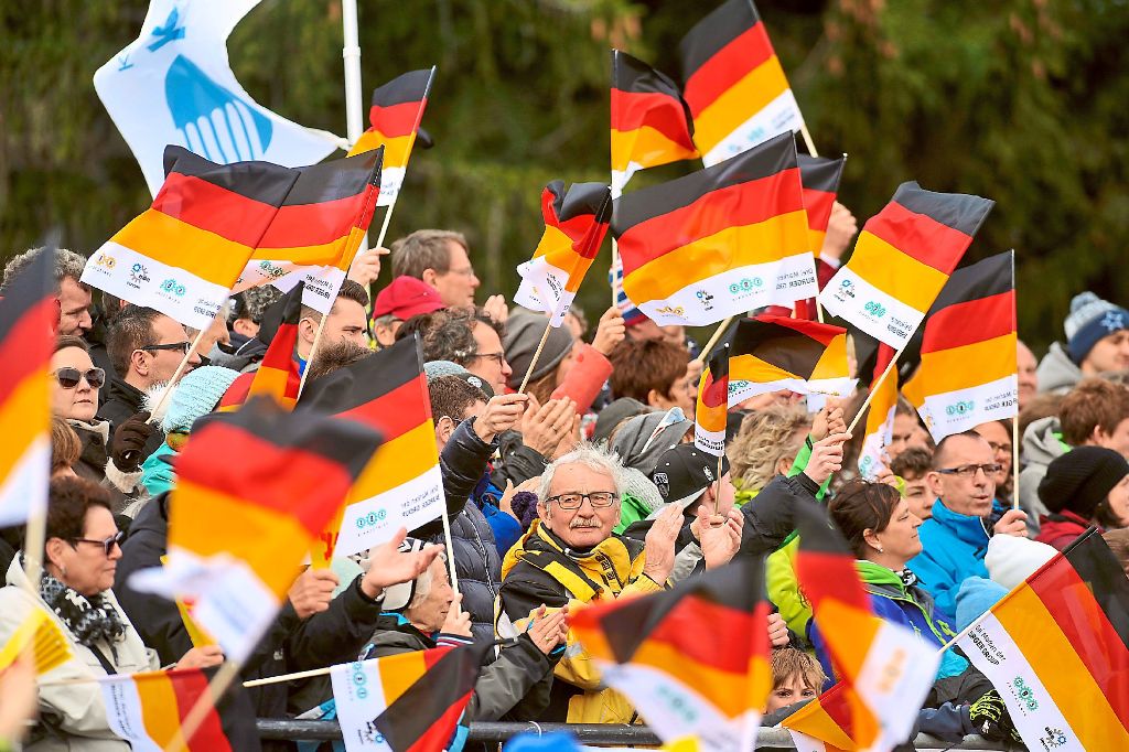 Bei der Siegerpräsentation gehen die Fahnen der deutschen Fans in die Höhe.