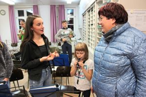 Amelie Schweizer (links) beschreibt, wie sie beim Musikverein Eintracht Göttelfingen Klarinette lernt. In der Zwischenzeit versucht Anna (Mitte) ihr Talent am Mundstück.  Foto: Feinler Foto: Schwarzwälder Bote