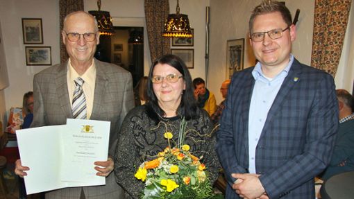 Günter Jeschonek (links) hat von Finanzbürgermeister Steve Mall die Landesehrennadel entgegen genommen, seine Frau Ljubow einen Blumenstrauß zum Dank für ihre Unterstützung. Foto: Horst Schweizer