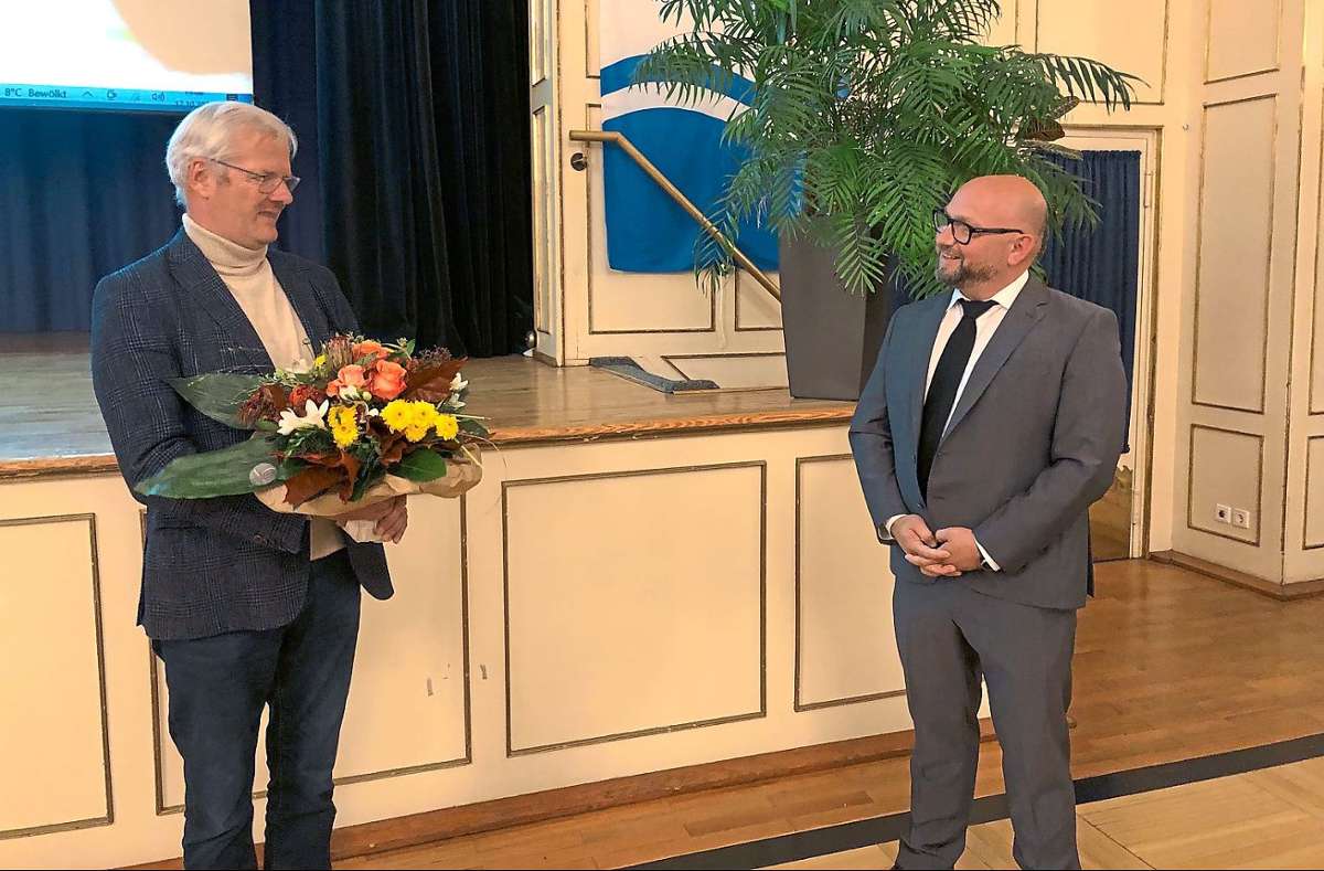 Volker Kliewer (links) gratuliert Roberto Chiari zum Sieg und überreicht ihm einen Blumenstrauß.
