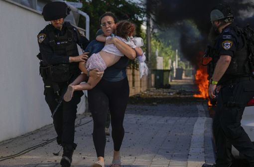 Israelische Soldaten retten eine Frau mit Kind. Foto: dpa/Tsafrir Abayov