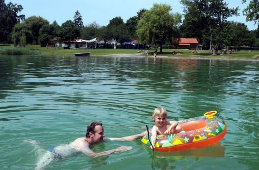 Ein Vater schwimmt am Donnerstag mit einem Kind vor dem Strandbad in Gaienhofen im Bodensee. Foto: dpa