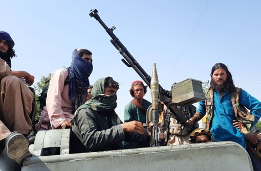Schwer bewaffnete Taliban-Kämpfer fahren in einem Fahrzeug durch Mehtarlam, der Hauptstadt der Provinz Laghman. Foto: dpa/Str