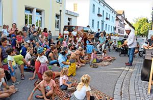 Bei Märchenerzählungen machen es sich Kinder auf in der Straße ausgelegten Teppichen gemütlich. Foto: Stephan Hübner