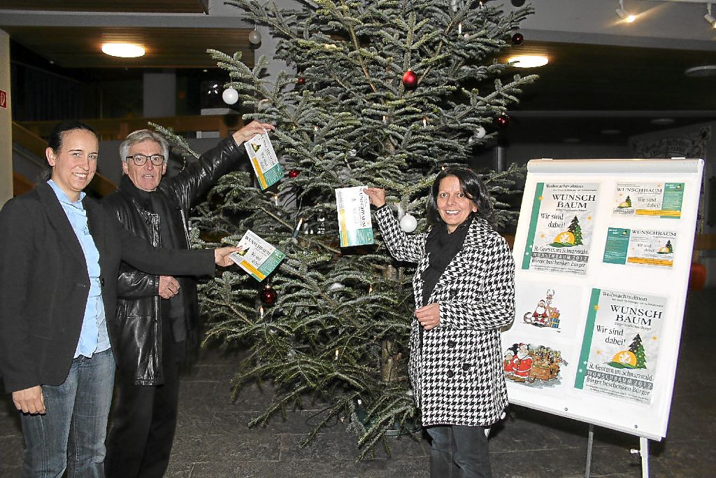 Diana Weißer (links), Antonia Musacchio Torzilli und Hans Uwe Lorius starteten gestern die Weihnachtsaktion offiziell vor dem Wunsch(Christ)baum, der bereits im Rathaus-Foyer steht. Foto: Vaas