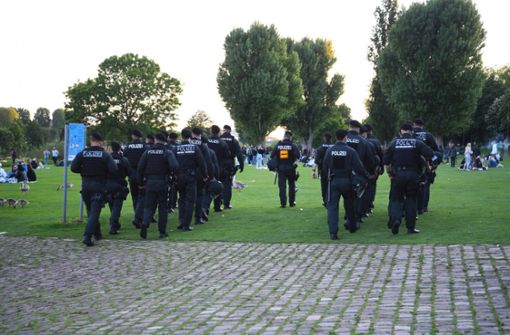 Polizeibeamte unterwegs auf der Neckarwiese in Heidelberg. Foto: dpa/Rene Priebe