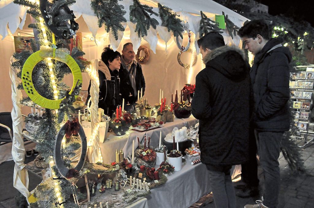 Passend zum ersten Advent werden Dekorationen mit Kerzen und Tannenzweigen angeboten.