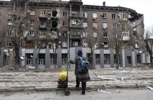 Eine Anwohnerin betrachtet ein bei schweren Kämpfen beschädigtes Wohnhaus in einem von den von Russland unterstützten Separatisten kontrollierten Gebiet in Mariupol. Foto: dpa/Alexei Alexandrov