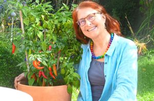 Tina Mürle umarmt ihren selbst angebauten Paprika. Sie setzt auf eine klimabewusste Ernährung, die möglichst mit kurzen Transportwegen einhergeht. Foto: Thomas Fritsch