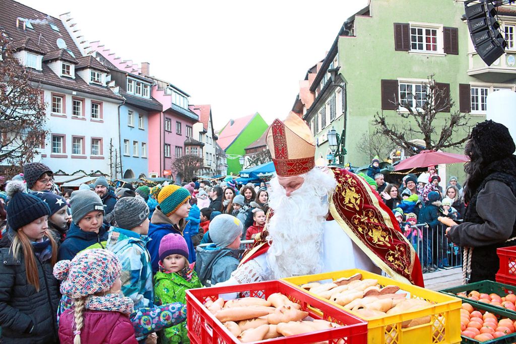 Kinder und Eltern, soweit aus Auge reicht,  warten auf den Nikolaus und Knecht Ruprecht, der 400 Weckmänner und Mandarinen verteilt.   Fotos: Bächle