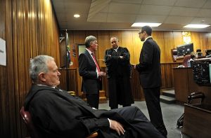 Oscar Pistorius (rechts) mit seinem Verteidigerteam im Gerichtssaal in Pretoria: Barry Roux (con links), Brian Webber und Kenny Oldwage. Foto: dpa